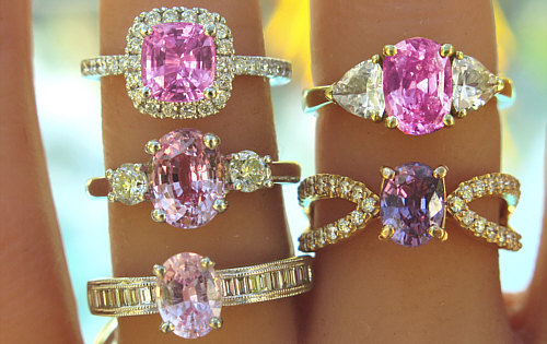 Pink sapphire engagement rings shown on hand, ranging from light pink to vivid and purplish pink.