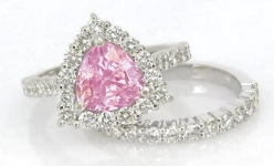 Natural trillion cut pink sapphire ring with a diamond halo in 14k white gold shown with its matching diamond band