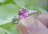 Natural Oval Pink Sapphire Engagement Ring with Round White Sapphire Sides in ornate 14k white gold band