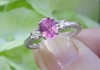 Natural Oval Pink Sapphire Engagement Ring with Round White Sapphire Sides in ornate 14k white gold band